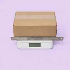 Sealed parcel on a scale with a metal ruler
